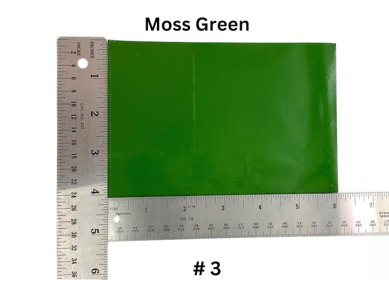 May include: A close-up of a moss green vinyl sheet, measured with a ruler. The sheet is 6 inches wide and 6 inches long. #3