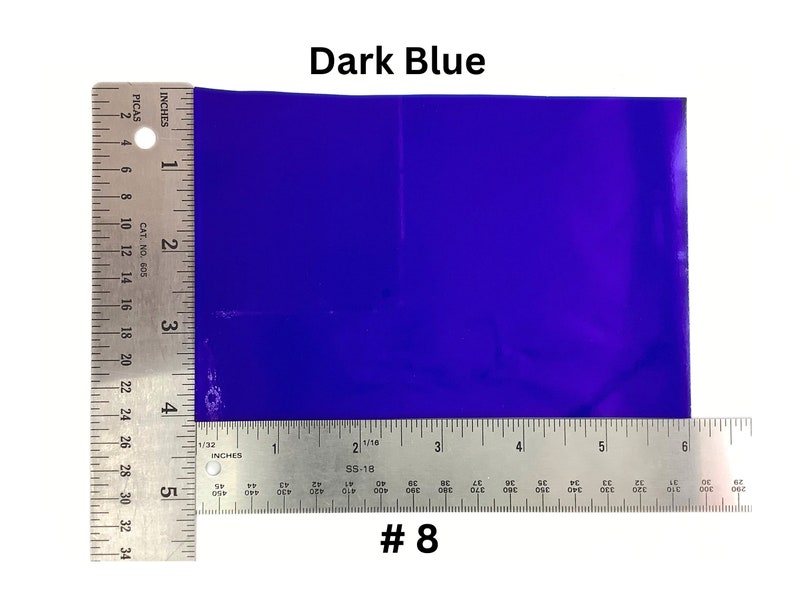 May include: A dark blue sheet of paper measured with a ruler. The ruler shows inches and picas. The paper is 5 inches by 6 inches. #8