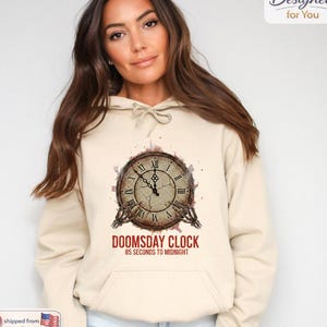 May include: A white ceramic mug with a black handle and the text "But First, Coffee" in a black, handwritten-style font. The mug is on a white surface.