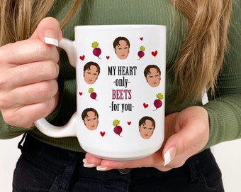 May include: White ceramic mug with the text "MY HEART -only- BEETS -for you-". The mug features illustrations of beets, hearts, and a character's face. The mug is held by a person.