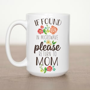 May include: White ceramic mug with the text "IF FOUND IN MICROWAVE please RETURN TO MOM" in a whimsical font. The mug is decorated with watercolor floral accents in shades of red, orange, yellow, and green. The mug has a large handle.