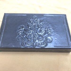 Encantadora caja chapada en hojalata con diseño de pájaro en relieve en la tapa.
