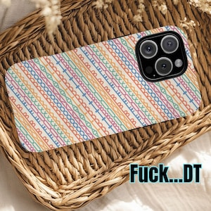 May include: A phone case with a colorful geometric pattern in pastel shades of pink, orange, blue, and green. The case is resting in a woven basket. The text "Fuck...DT" is visible on the bottom right corner.