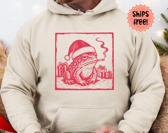 Smoking Toad Christmas Sweatshirt, Lino Cut Style Santa Toad with Cigarette Hoodie, Holiday Frog Lover Gift; add custom sleeve