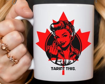 May include: White 11 oz ceramic mug with a red maple leaf design and a retro illustration of a woman giving the middle finger. The text "TARIFF THIS." is printed below the illustration.