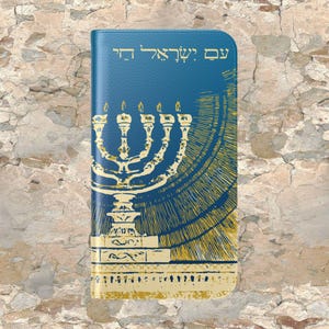 Könnte beinhalten: Eine blaue Handyhülle mit einem goldenen Menora-Design und dem hebräischen Text "עם ישראל חי", der mit "Das Volk Israel lebt" übersetzt wird.