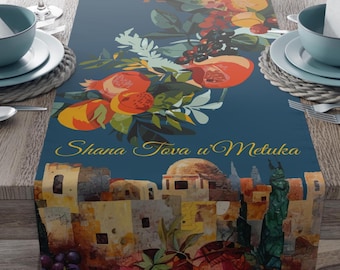 May include: A blue table runner with a colorful illustration of pomegranates, grapes, and a cityscape. The text "Shana Tova u'Metuka" is written in gold lettering.