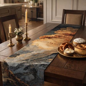 May include: A table runner with a landscape design in shades of blue, beige, and brown, depicting mountains and clouds. The runner is on a wooden table, with food and candles. Text is visible on the runner.