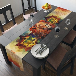 May include: A decorative table runner featuring a lion's head with a Star of David design. The runner has a watercolor effect with text in Hebrew. The color palette includes shades of orange, yellow, blue, and green.
