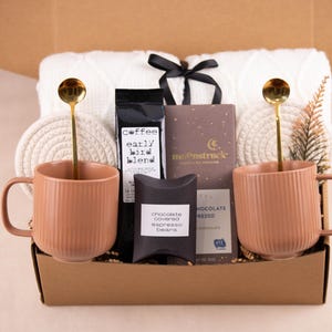 K&ouml;nnte beinhalten: Ein Set aus drei Keramikbechern mit gesprenkelter, matter Oberfl&auml;che. Die Becher sind in Creme-, Hellgrau- und Dunkelgraut&ouml;nen gehalten. Jeder Becher hat ein schlichtes, modernes Design und einen abgerundeten Henkel.