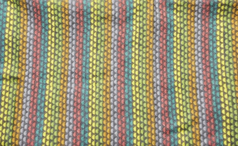 May include: Textile with a vertical striped pattern. The stripes alternate in color, including yellow, green, red, and blue. The fabric has a textured appearance, with small, repeating dot-like patterns.