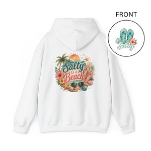 May include: A white hooded sweatshirt featuring a large circular graphic on the back with a sunset, palm tree, flip-flops, sunglasses, starfish, and seashells, with the text Salty as a Beach. A small circular front logo shows flip-flops and Salty.