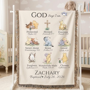Pode incluir: Uma manta tecida na cor creme com personagens do Ursinho Pooh, textos religiosos e o nome ZACHARY com a data 26 de julho de 2026. O design inclui nove ilustrações com legendas como Protected, Blessed e Loved.