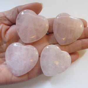 Puede incluir: Cuatro piedras de cuarzo rosa en forma de corazón rosa. Las piedras son lisas y pulidas.