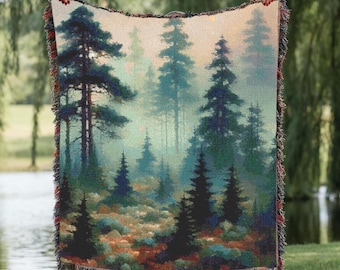 May include: A woven throw blanket featuring a forest landscape with tall pine trees in shades of dark green, blue, and brown. The scene depicts a misty woodland with a textured, multi-colored fringe border along all four edges of the rectangular fabric.