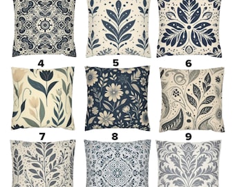 May include: Nine decorative throw pillows with various patterns. Designs include floral, geometric, and botanical motifs in shades of blue, gray, and cream. The pillows are square-shaped, perfect for adding a decorative touch to any living space.