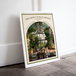 Może przedstawiać: Okładka magazynu Architectural Digest, przedstawiająca zdjęcie wnętrza szklarni z dużym łukowatym oknem. Tekst na okładce brzmi: "Architectural Digest", "Najnowsze wydanie: luty 2023", "Edycja 97: Oliwkowa Opulencje" i "Projektant: Audrey Willingham".