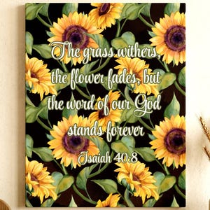 May include: A canvas print featuring a floral pattern of yellow sunflowers with dark purple centers and green leaves against a black background. The text "The grass withers, the flower fades, but the word of our God stands forever Isaiah 40:8" is displayed.