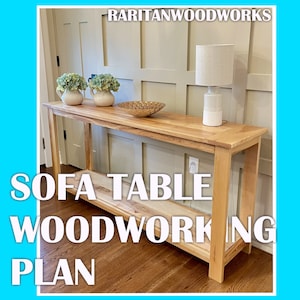 May include: A light wood sofa table with a lower shelf. The table has a simple design with straight legs and a rectangular top. The table is shown in a home setting with a lamp and decorative items on top.
