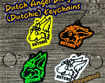 May include: Four Dutch Angel Dragon (Dutchie) keychains with different expressions. Each keychain features a black outline of a dragon head with a different colored background: yellow, orange, green, and white. The text "DUTCHIE" is printed on each keychain.