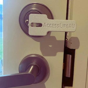 May include: A white plastic key tag with the text "ACCESSLIFEA.U" attached to a silver door handle.