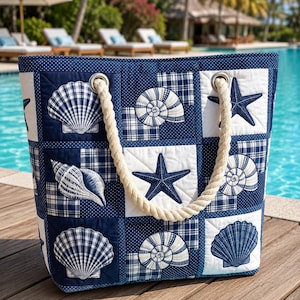 May include: A navy and white quilted tote bag with a nautical theme. The bag features a patchwork design with seashell and starfish appliqués. It has a sturdy rope handle, ideal for carrying beach essentials.