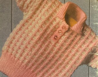 以下が含まれることがあります： 襟とボタン留めのあるピンクと白のストライプのニットセーター