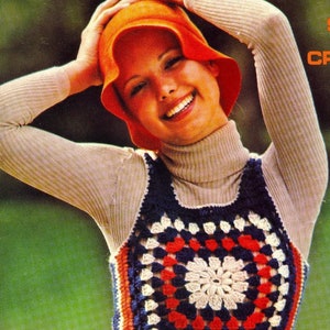 May include: A vintage-style crochet top with a square, floral-like design in red, white, and navy blue. The top is paired with an orange bucket hat and a beige turtleneck. The overall aesthetic is reminiscent of the 1970s.