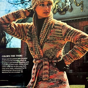 May include: A wrap-and-tie jacket with a marbled effect in shades of orange, brown, and white. The jacket has a shawl collar and a tie belt. The text "COLOR'S THE THING" is visible in the image.