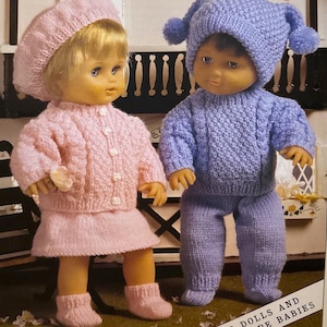 May include: Two knitted doll outfits, one pink and one blue, with matching hats. The outfits are designed for dolls and premature babies. The text "For Dolls and Premature Babies" is printed on the bottom of the image.