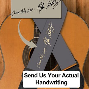 May include: Acoustic guitar with a gray guitar strap featuring the text "Choose Only Love..." and a signature in gold. The strap is attached to the guitar with black leather ends. The image includes the text "Send Us Your Actual Handwriting."