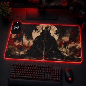 Può includere: Tappetino per mouse da gioco rettangolare con bordo a LED rosso e grafica di un guerriero samurai di fronte a una luna piena. Il tappetino include un'area di ricarica wireless ed è abbinato a tastiera e mouse neri.