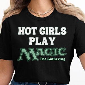 May include: Black t-shirt with the text "Hot Girls Play Magic The Gathering" in white and green.