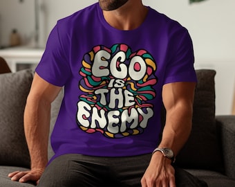 May include: Purple t-shirt with a colorful graphic design that says "Ego is the enemy".