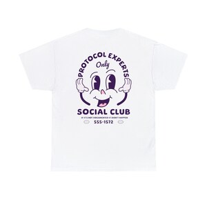 Op de afbeelding: Wit T-shirt met een paarse afbeelding van een cartoon gezicht met de tekst "Protocol Experts Only" en "Social Club" met de tekst "If it's not documented it didn't happen 555-1572" eronder.
