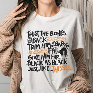 K&ouml;nnte beinhalten: Wei&szlig;es T-Shirt mit schwarzem Text, der "Twist the Bones and Bend Back the Trim Him of His Baby's Fat Give Him Fur Black as Black Just...Like...Thissss" lautet. Der Text ist handschriftlich. Eine schwarze Katzensilhouette ist im Text enthalten.
