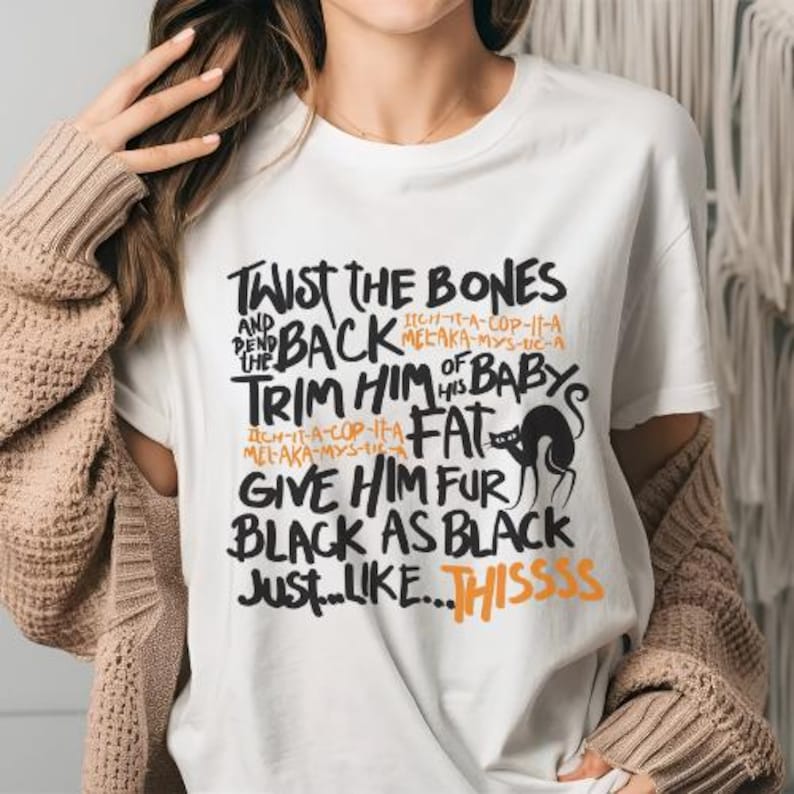 K&ouml;nnte beinhalten: Wei&szlig;es T-Shirt mit schwarzem Text, der "Twist the Bones and Bend Back the Trim Him of His Baby's Fat Give Him Fur Black as Black Just...Like...Thissss" lautet. Der Text ist handschriftlich. Eine schwarze Katzensilhouette ist im Text enthalten.