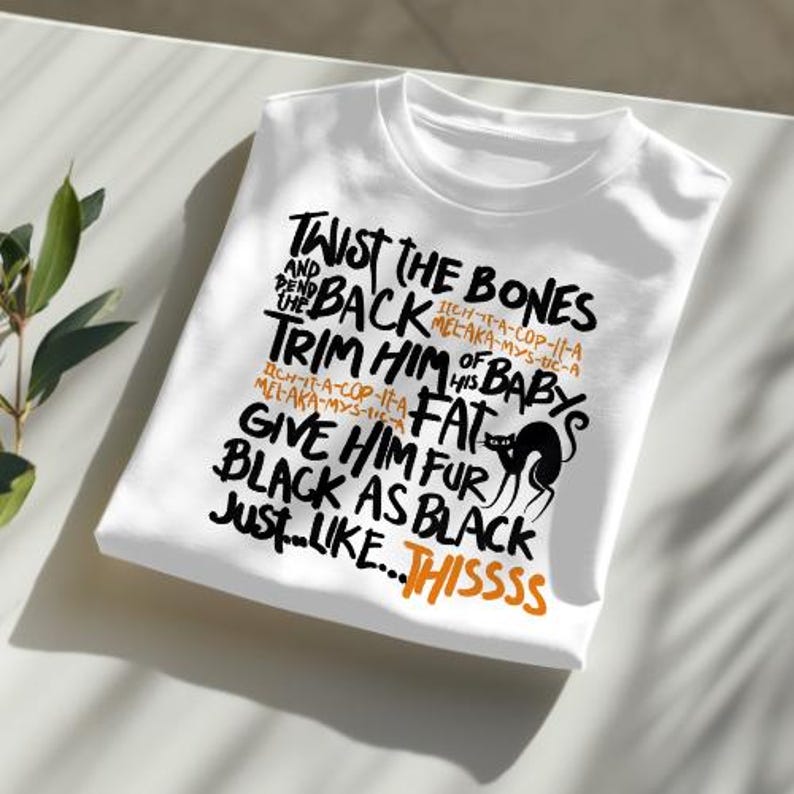 K&ouml;nnte beinhalten: Wei&szlig;es T-Shirt mit schwarzem Text, der "Twist the bones and back, trim him of his baby's fat, give him fur black as black just like...thissss" lautet. Der Text ist handschriftlich. Eine schwarze Silhouette einer Katze ist im Text enthalten.