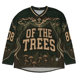 Puede incluir: Una camiseta de manga larga con cuello en V, que presenta un paisaje forestal verde oscuro con montañas, helechos y setas. El texto "OF THE TREES" está impreso en letras beige grandes en el pecho, con el número "808" en cada manga.