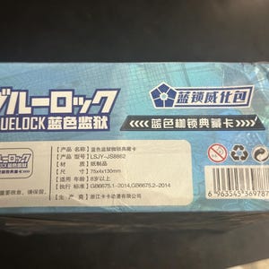 Puede incluir: Caja azul con texto japon&eacute;s y chino, con la palabra "BLUELOCK" en blanco. Las dimensiones son 75 x 4 x 130 mm. Incluye un c&oacute;digo de barras y varios s&iacute;mbolos.