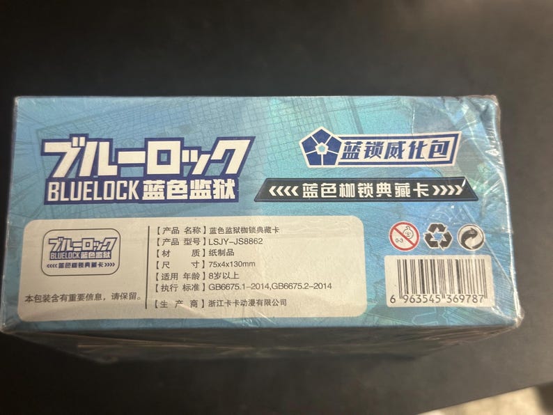 Puede incluir: Caja azul con texto japon&eacute;s y chino, con la palabra "BLUELOCK" en blanco. Las dimensiones son 75 x 4 x 130 mm. Incluye un c&oacute;digo de barras y varios s&iacute;mbolos.