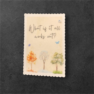 May include: A watercolor illustration of three trees in different seasons, with the text "What if it all works out?" on a beige background. The trees are a fall tree with orange leaves, a winter tree with bare branches, and a spring tree with green leaves. There are blue butterflies flying around the trees.