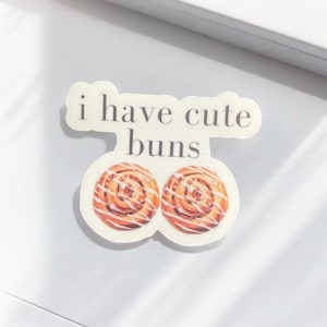 May include: White sticker with the text "i have cute buns" and two images of cinnamon rolls.