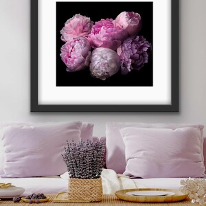 May include: A framed print of a bouquet of pink and purple peonies against a black background.