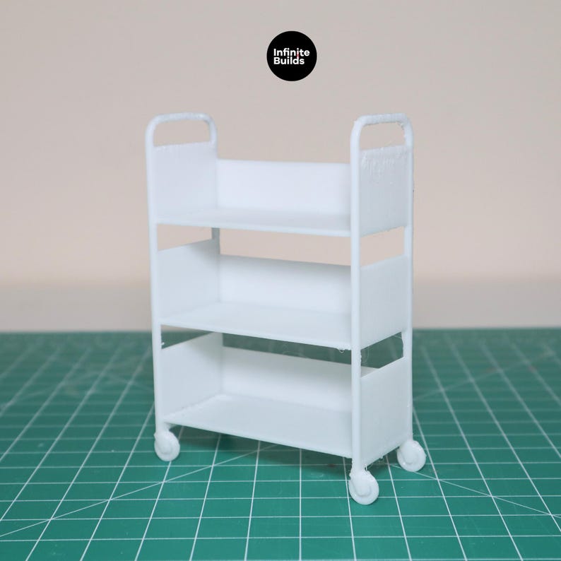 May include: A white three-tiered rolling cart with wheels. The cart is made of plastic and has a simple design.