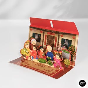 Puede incluir: Una tarjeta de felicitación desplegable roja que representa una escena familiar asiática tradicional. La tarjeta muestra una casa con figuras con ropa colorida, con un techo rojo y un suelo estampado. La tarjeta está abierta, revelando la escena 3D.