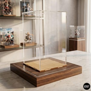 May include: A clear acrylic display case with a rectangular wooden base. The case features transparent vertical panels and a light-colored wooden floor insert. The base is made of dark wood with a smooth finish. The text Infinite Builds is visible.