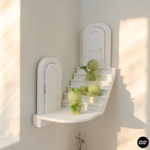 Puede incluir: Un juego de tres tazas de cerámica con un acabado mate moteado. Las tazas son de color crema, gris claro y gris oscuro. Cada taza tiene un diseño simple y minimalista y un asa redondeada. Para café o té.