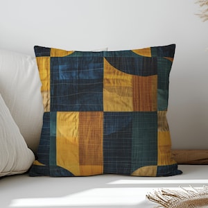 May include: A decorative throw pillow with a geometric pattern in shades of blue, yellow, and brown. The pillow is made of a soft, textured fabric and has a square shape.