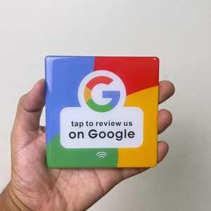 Könnte beinhalten: Ein quadratischer Aufkleber mit einem Google-Logo und dem Text "tap to review us on Google". Der Aufkleber ist in den Farben Blau, Rot, Grün und Gelb gehalten.